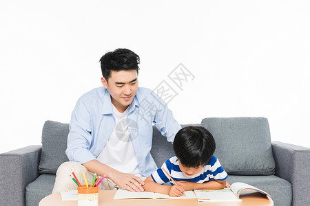 沙发上父亲辅导孩子写作业笔筒高清图片素材