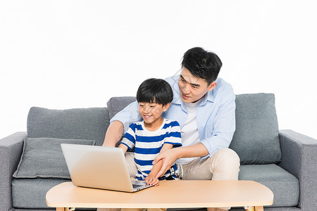 儿童用电沙发上父亲指导孩子用电脑背景