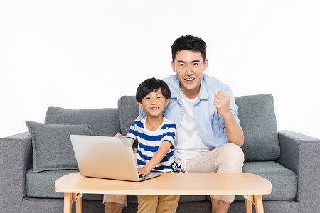 儿童用电沙发上父亲指导孩子用电脑背景
