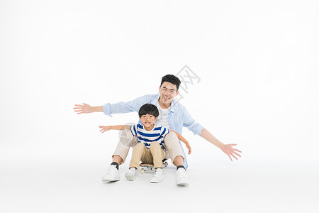 爸爸和儿子玩滑板高清图片