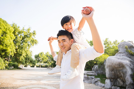 男人裸背公园里父亲把孩子架到背上背景