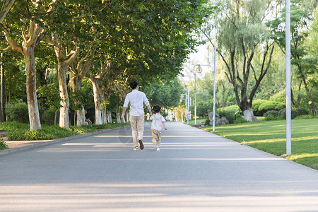 跑步父子公园里父子牵手跑步背影背景