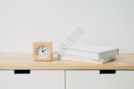 桌子上的闹钟和书籍背景图片