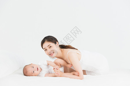 床婴儿母婴妈妈在床上逗宝宝开心背景