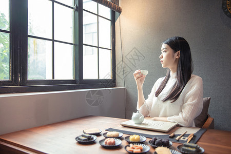 窗边品茶的女生背景图片
