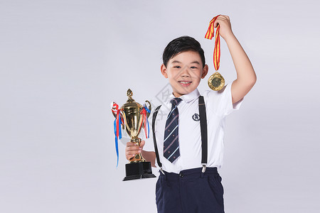 男孩拿着奖杯和奖牌背景图片