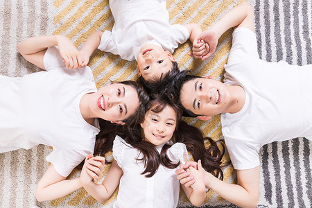 幸福的一家人躺在地毯上背景图片