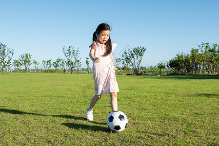 小孩子草地上踢足球图片