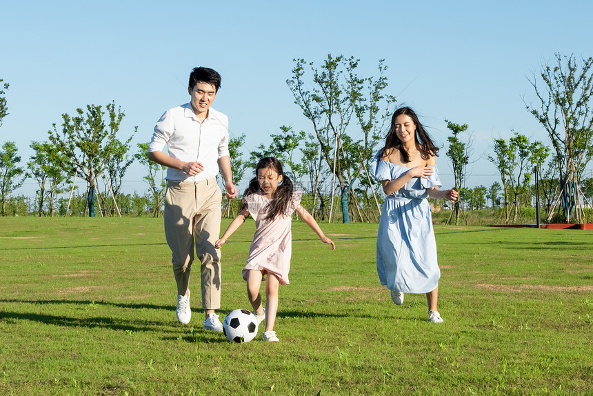 一家人户外游玩踢足球图片