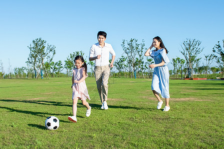 一家人户外游玩踢足球图片