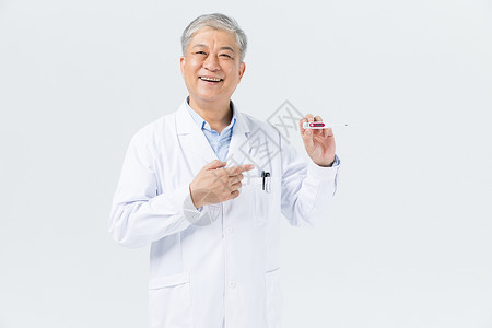 男性假牙展示老年男性医生拿假牙背景