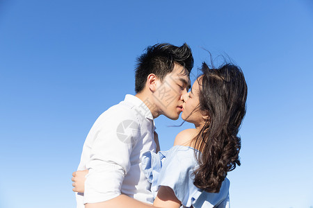 年轻情侣亲吻背景图片