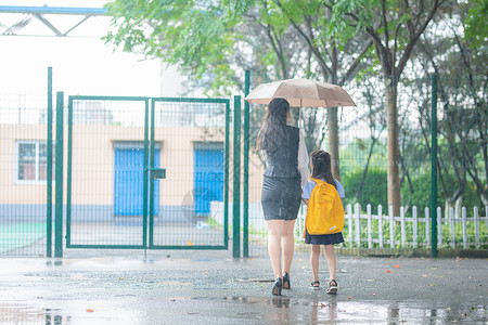 撑着雨伞孩子妈妈送孩子上学背景