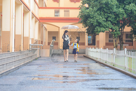 雨天男孩女孩妈妈送孩子上学背景