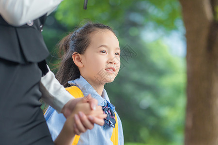 撑着雨伞孩子妈妈送孩子上学背景