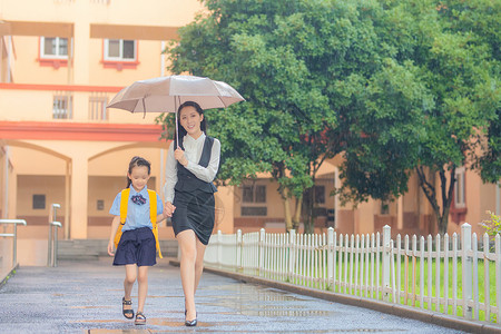 雨天男孩女孩妈妈送孩子上学背景