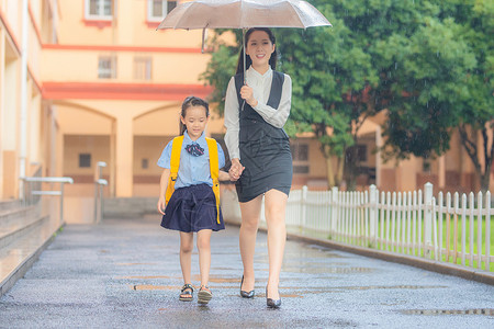 撑着雨伞孩子妈妈送孩子上学背景