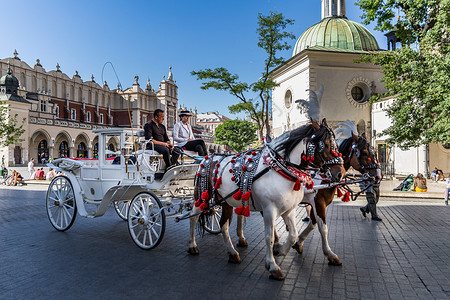 广场上的人波兰名城克拉科夫老城广场上的游览马车背景