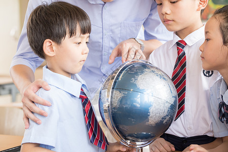 老师教学生使用地球仪返校高清图片素材
