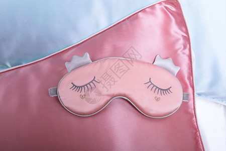 单面枕头套眼罩放在粉色枕头套上背景