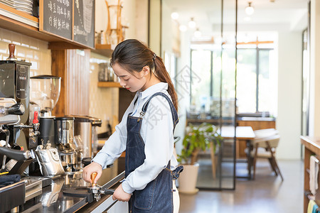 年轻美女咖啡馆咖啡师研磨咖啡粉背景