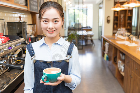 女性咖啡师手拿咖啡背景图片