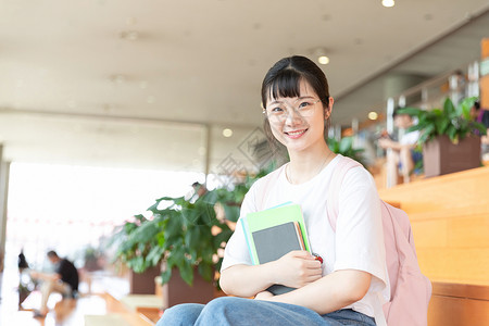 图书馆拿书的女生背景图片