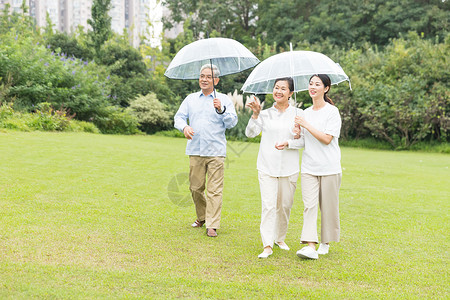 年轻男性撑伞幸福一家人雨天散步背景