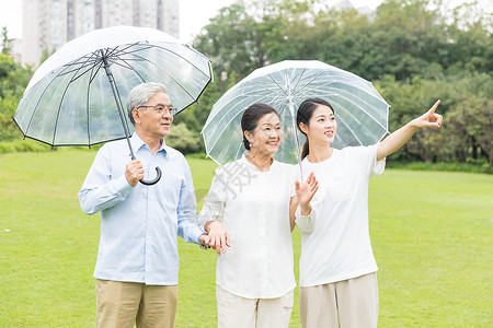 年轻男性撑伞幸福一家人雨天散步背景