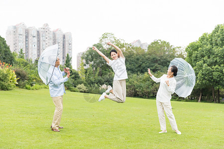 年轻男性撑伞幸福的一家人背景