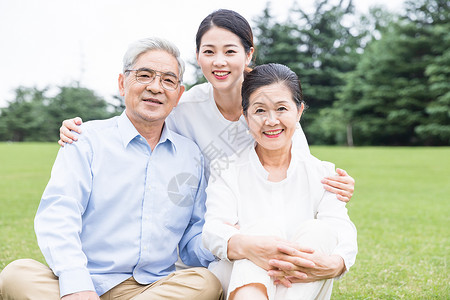 草地上幸福依靠的一家人高清图片