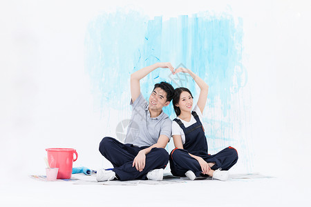 刷油漆的手年轻夫妻刷墙装修背景