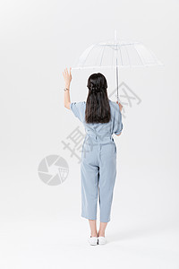 年轻美女撑伞背影背景图片