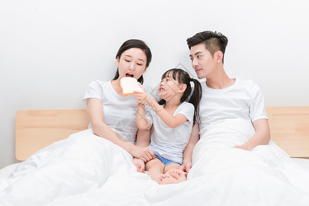 一家人躺在床上吃早餐高清图片