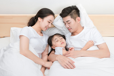 躺在床上的温馨一家人孩子高清图片素材