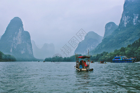 春日微雨中的桂林漓江竹筏漂流图片
