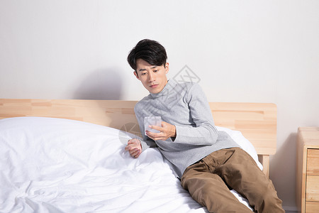 躺在床上玩手机的男性模特高清图片素材