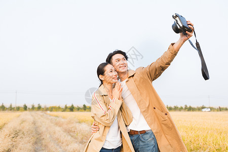 无人机拍照年轻情侣拿相机拍照背景