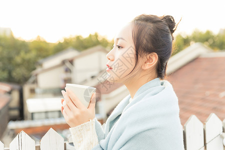 阳台上女孩温暖冬日年轻女性喝水背景