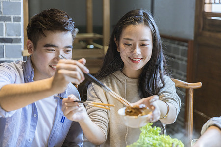 火锅店情侣夹菜背景图片