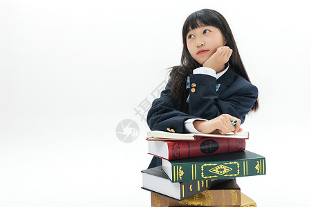 女学生靠着书本写作业高清图片