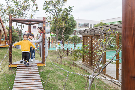 幼儿园老师带孩子排队过桥高清图片