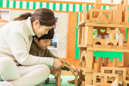 幼儿园老师陪孩子搭积木高清图片