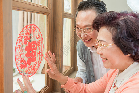 老年夫妻新年贴窗花高清图片