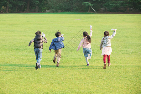 男生玩纸飞机草地上玩纸飞机的孩子们背景