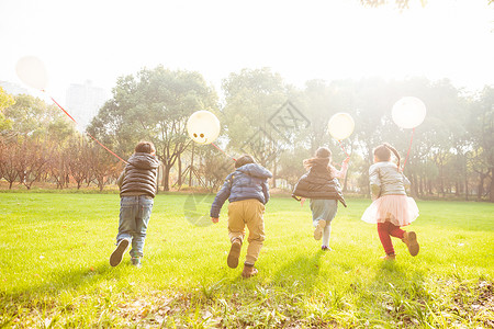 拿气球的男孩阳光下快乐儿童们奔跑背景