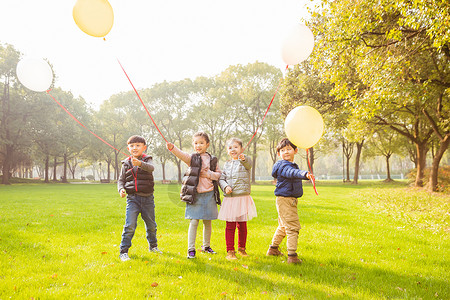 阳光下快乐儿童们和气球背景图片