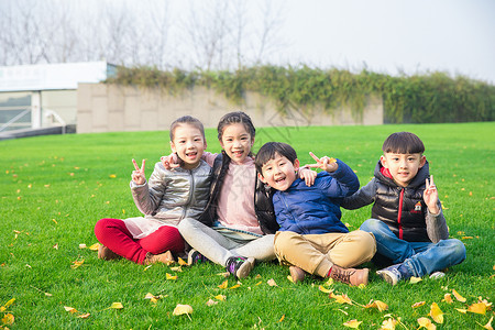 男童女童儿童坐在草坪上玩耍背景