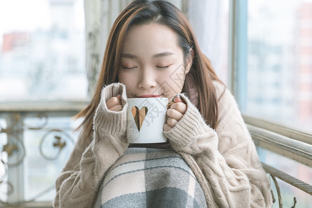 取暖美女冬季手捧杯子背景