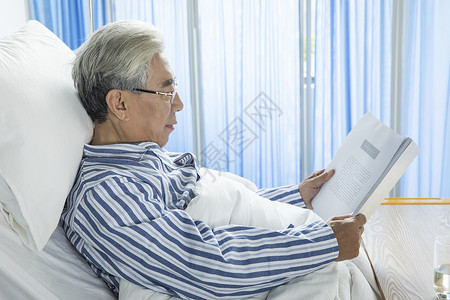 老年病人病床看书疼痛高清图片素材